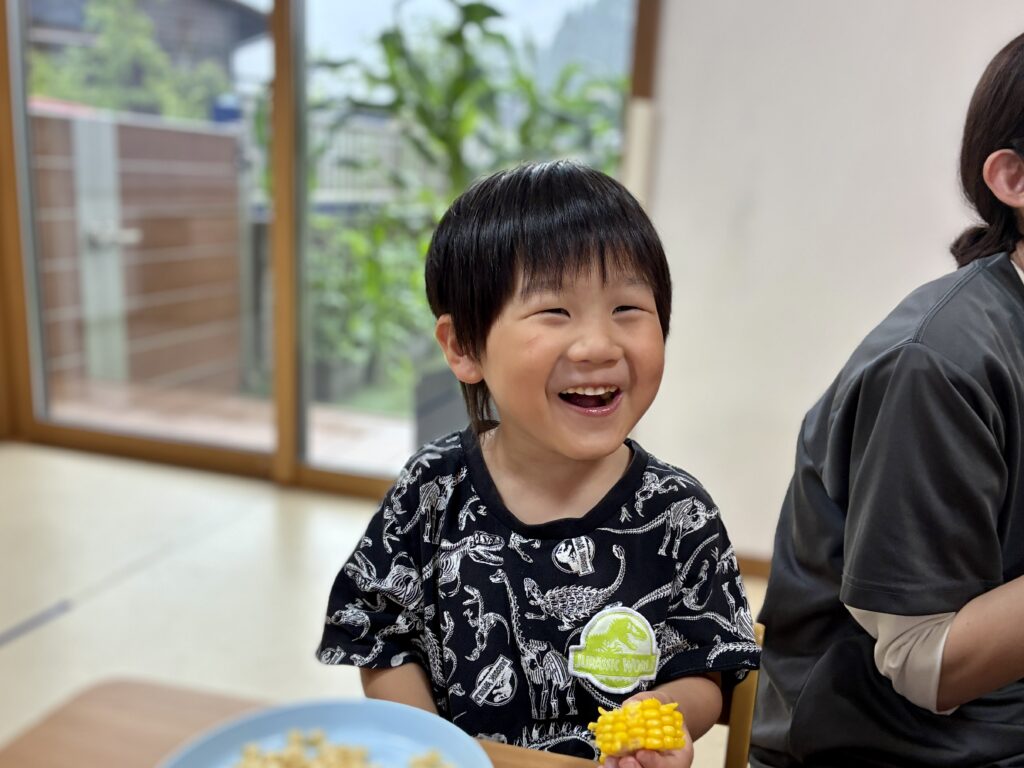 おやつでトウモロコシを味わうこども