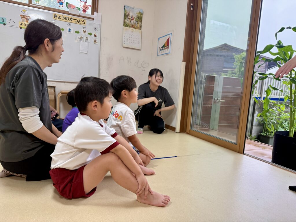 トウモロコシの苗を見て何ができるかを考えるこども
