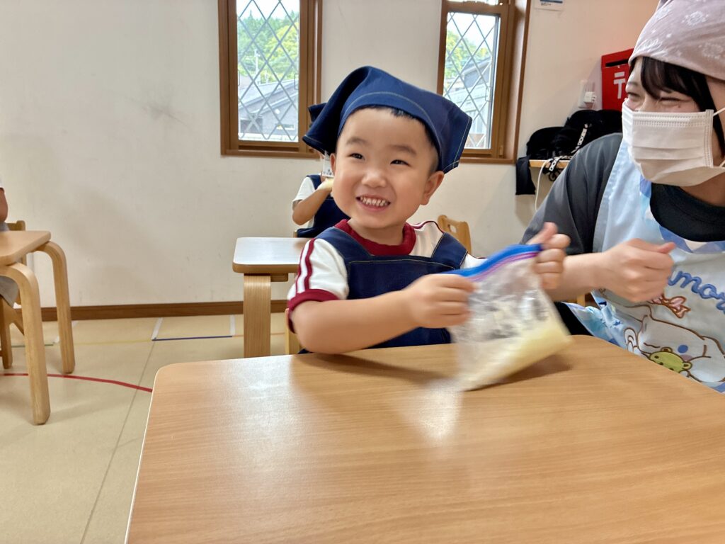 クッキー作りで材料を混ぜるこども