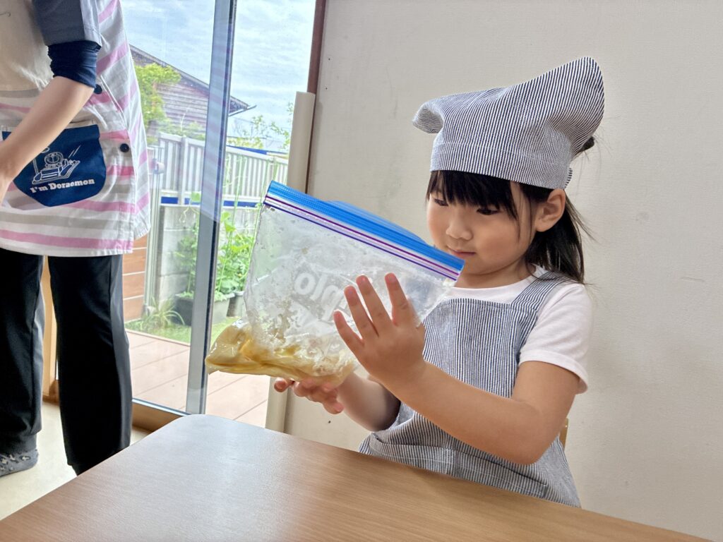 クッキー作りで材料を混ぜるこども