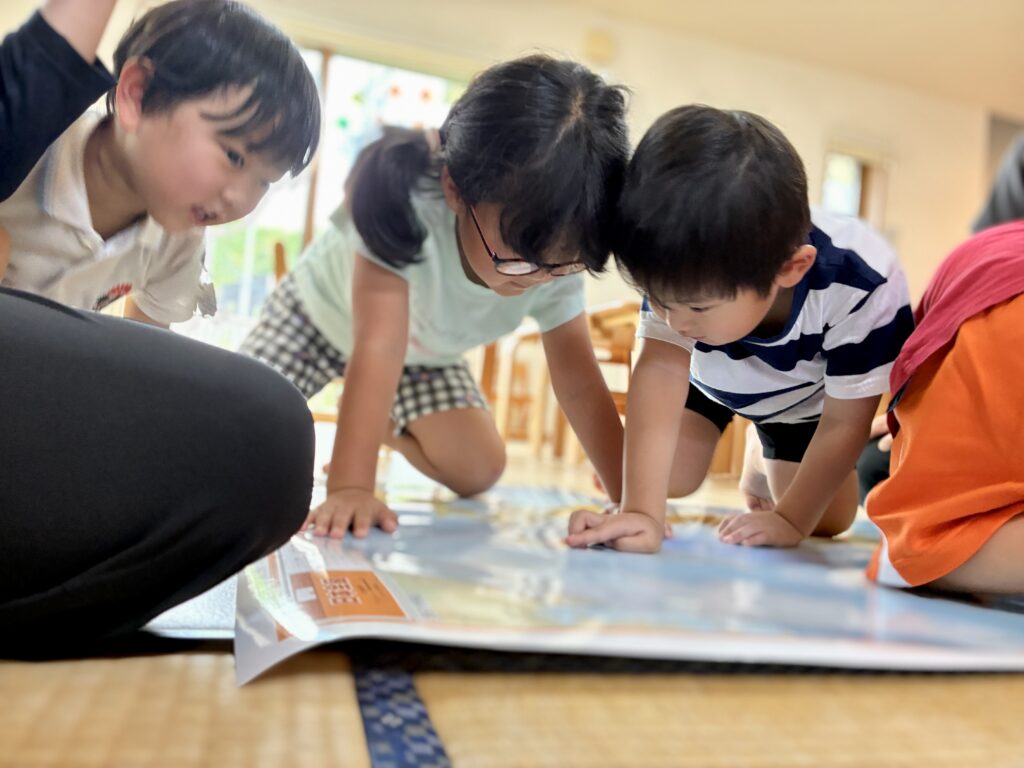 鹿児島市・日置市からこどもたちが通う児童発達支援事業所(療育支援事業所)アナベルキッズで、 地図を囲んで考えている。
