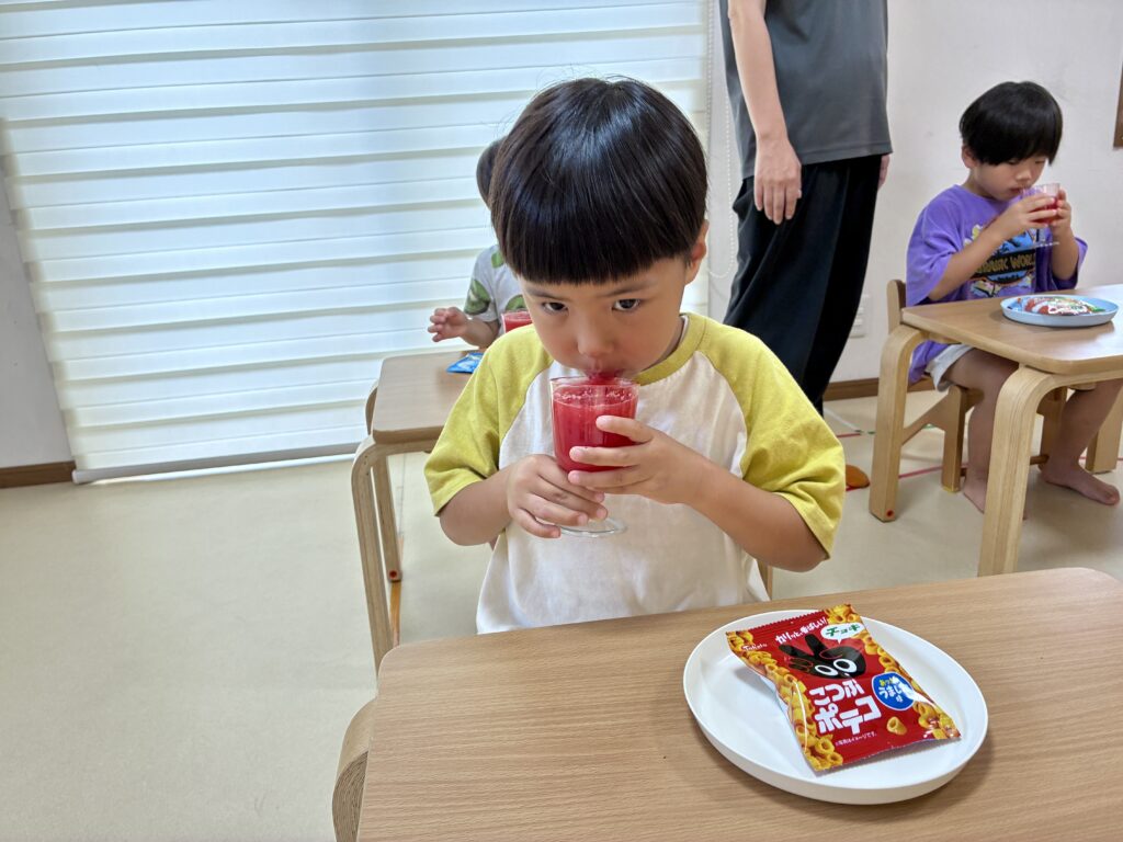 完成したスイカジュースを味わうこども