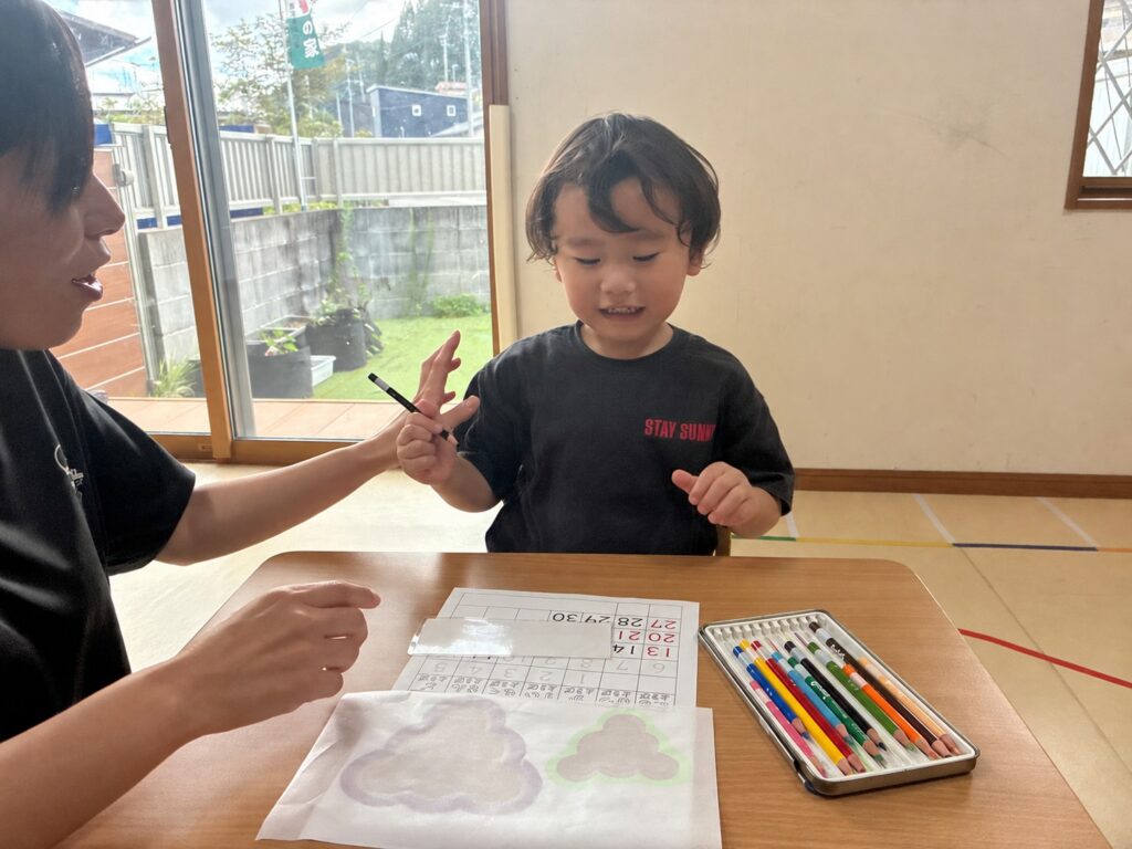 色鉛筆を手に、カレンダー作りを始める場面