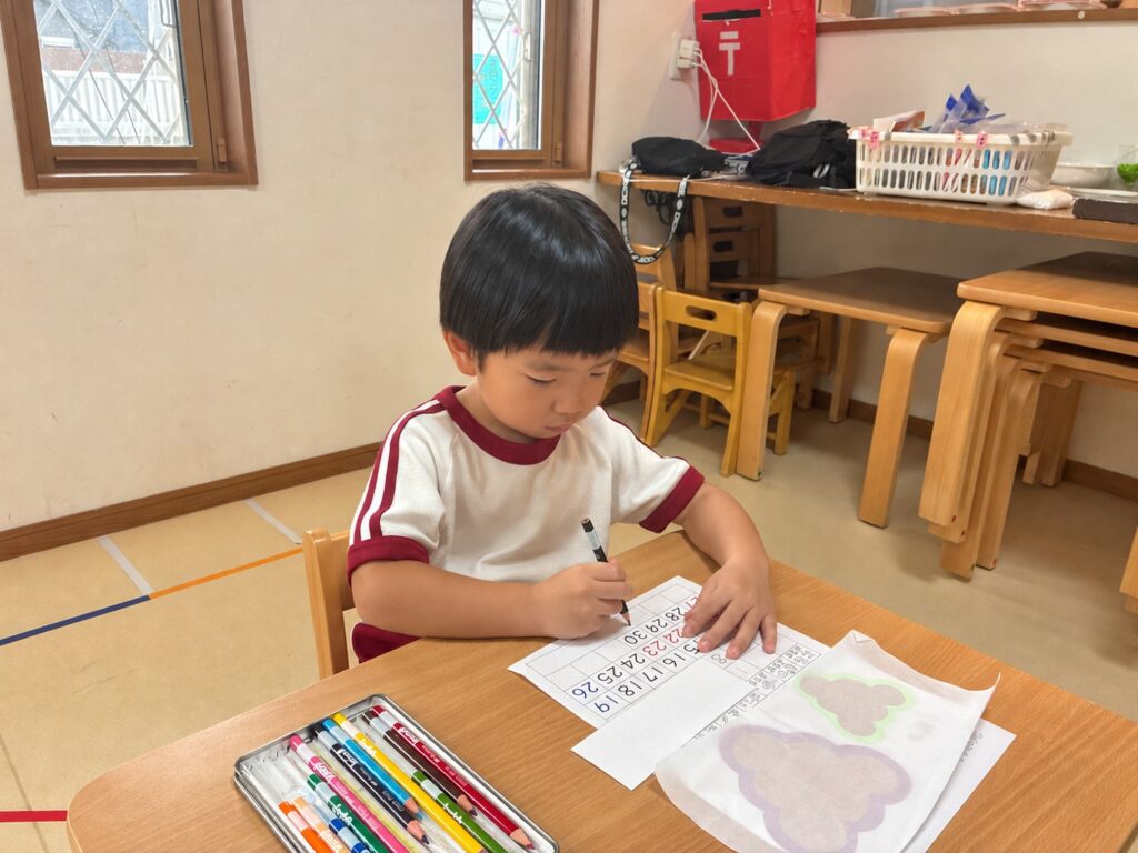 机に向かってカレンダーに描き込む様子
