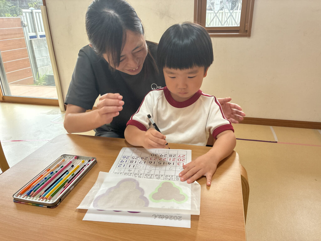 スタッフに見守られながら描く様子