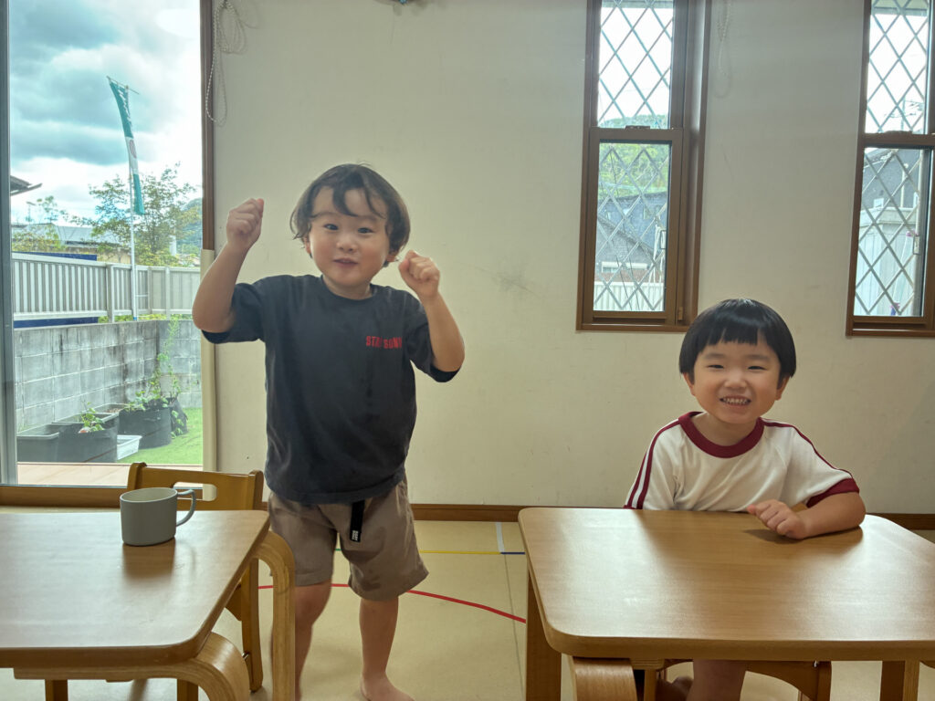 机を囲んで笑顔を見せるこどもたち