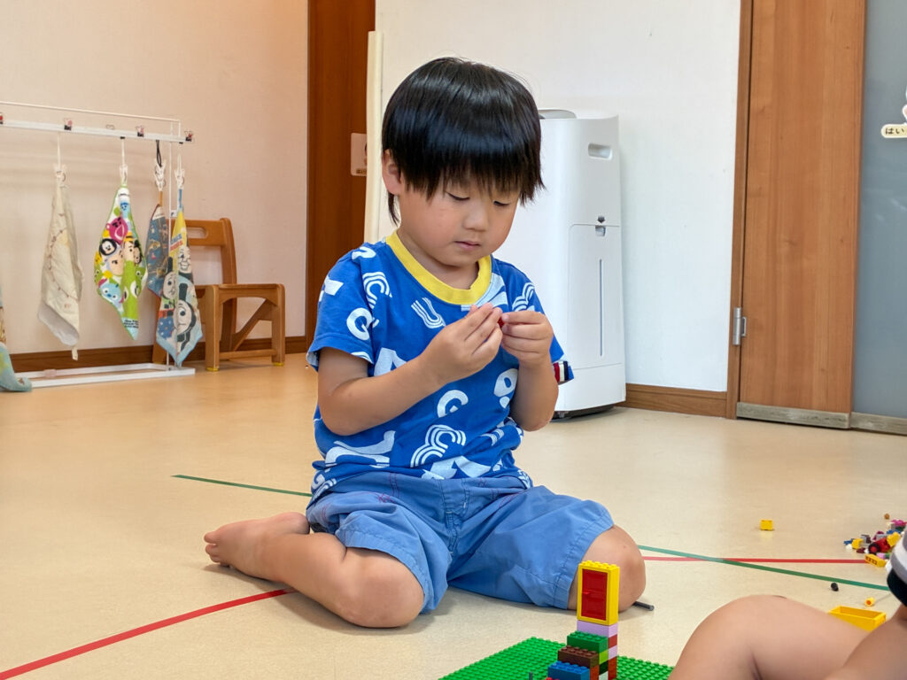 小さなブロックを両手で組み合わせる様子