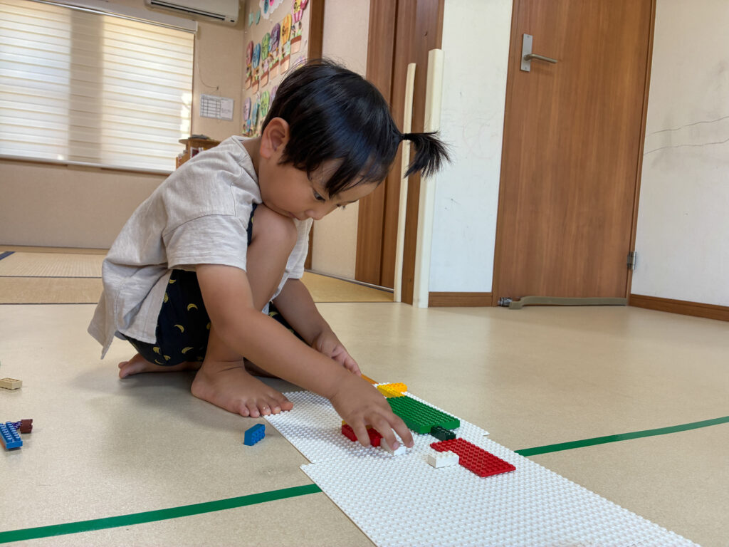 白い土台に色の違うブロックを並べる様子