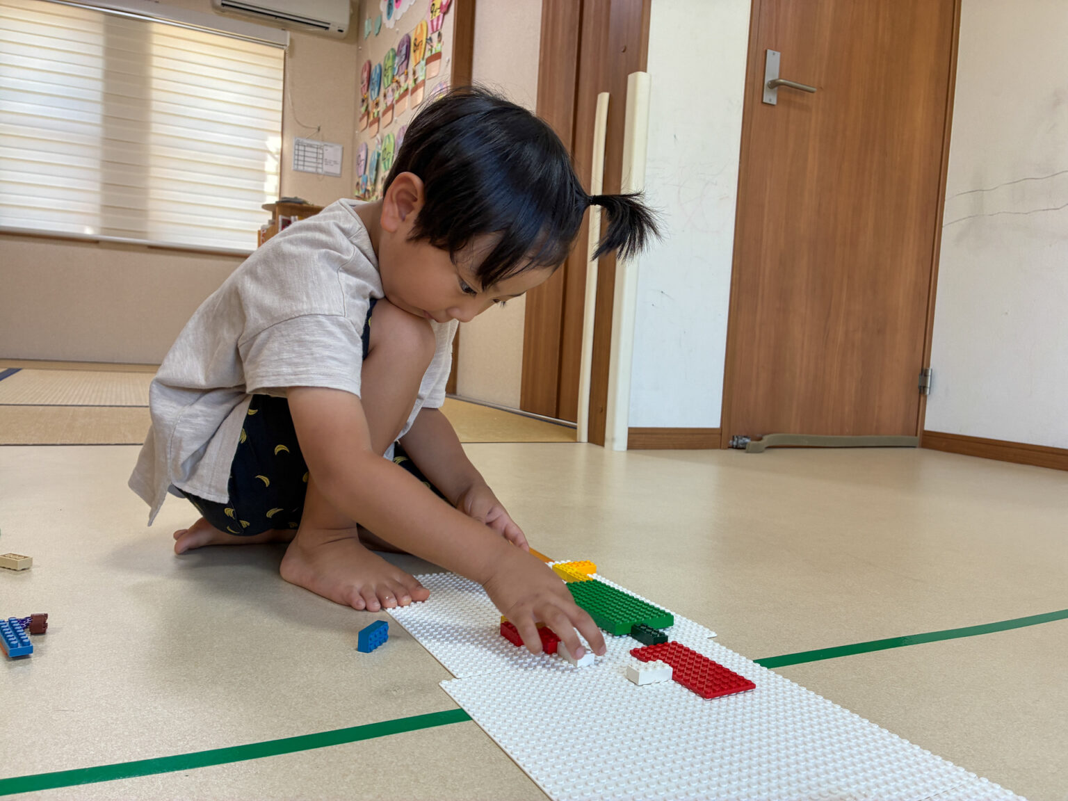 白い土台に色の違うブロックを並べる様子