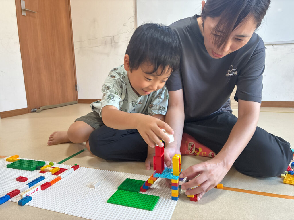 スタッフと並んでブロックを積む様子