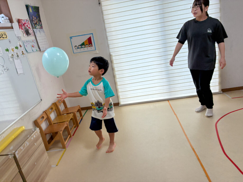 浮かんだ風船に手を伸ばす様子