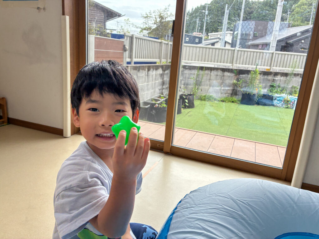 緑のボールを手にして見せる様子