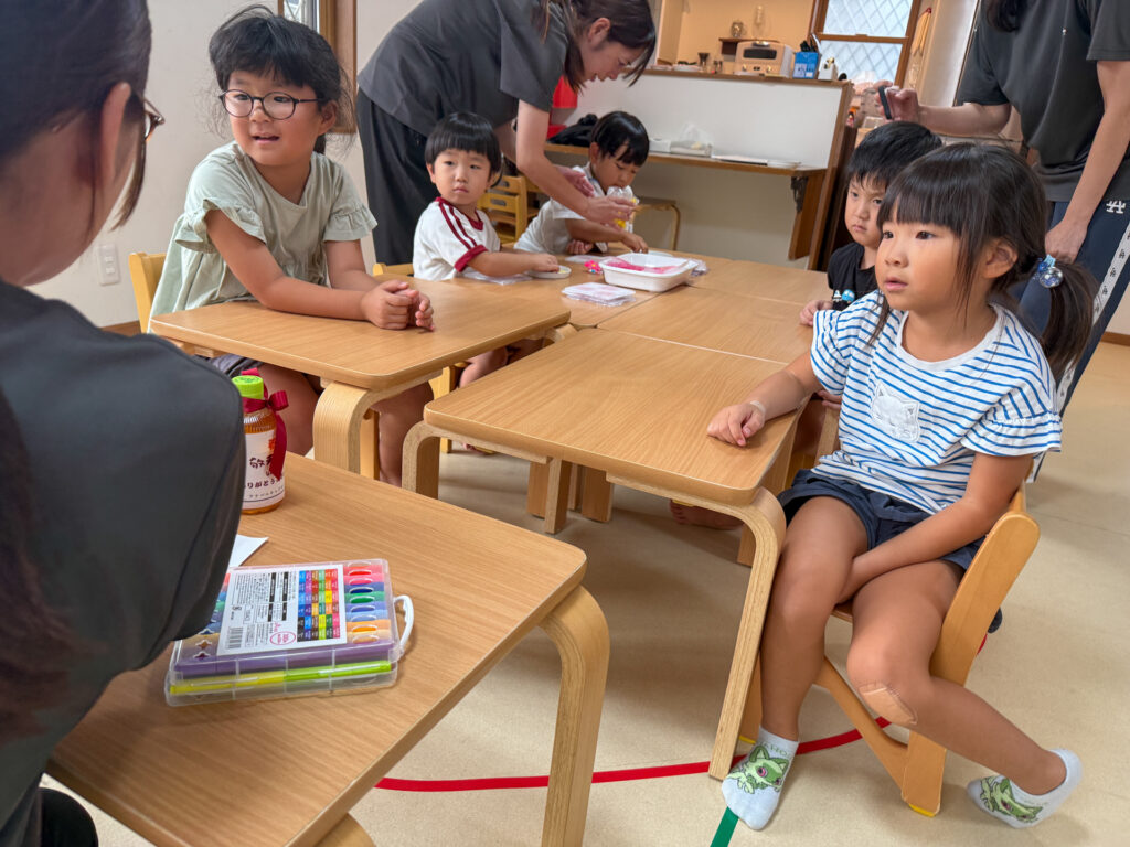 机を囲んでプレゼント作りの話を聞く様子