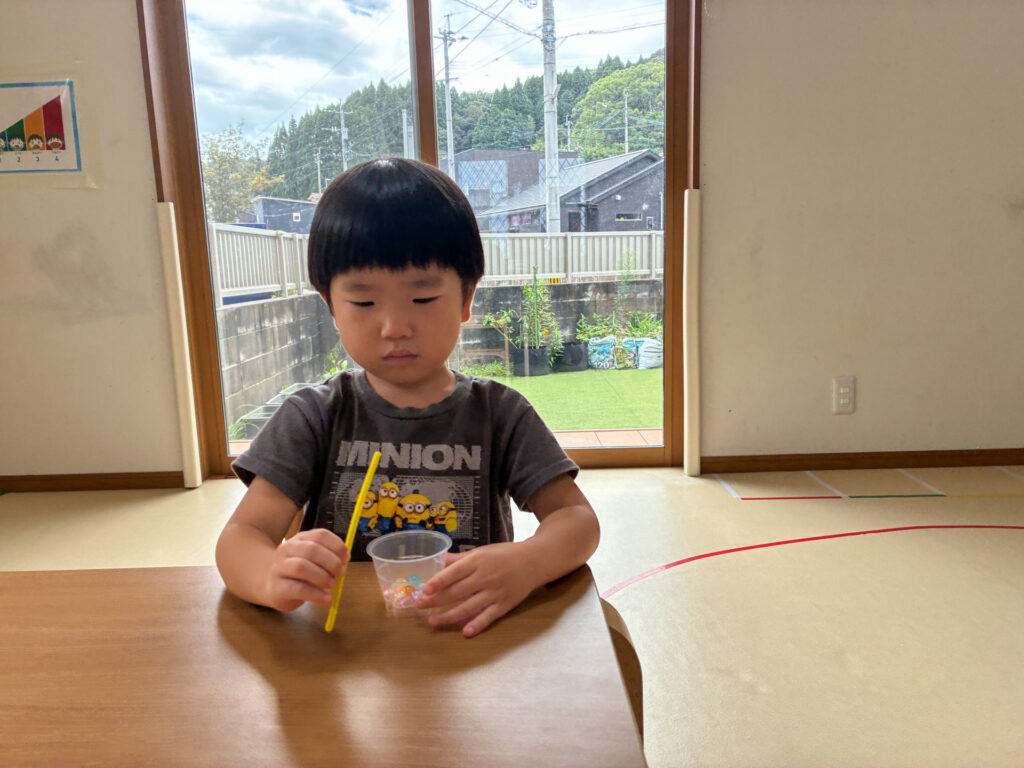 モールとビーズ入りのカップを手にする様子
