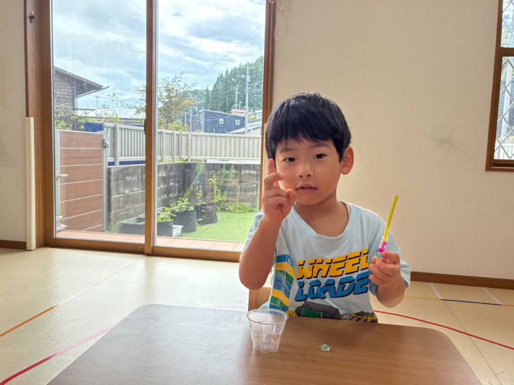 小さなビーズを指先でつまんで見せる様子