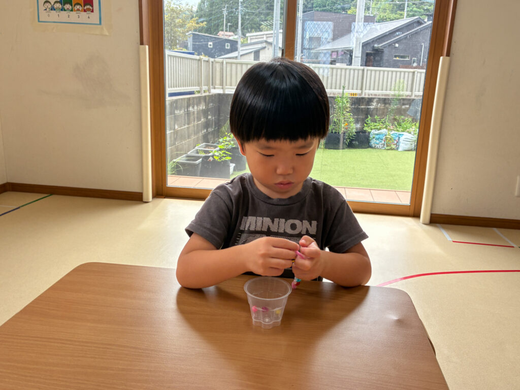 モールにビーズを通す手元