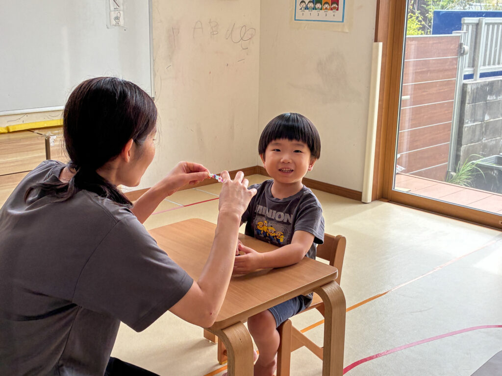 スタッフと向かい合って笑顔を見せる様子