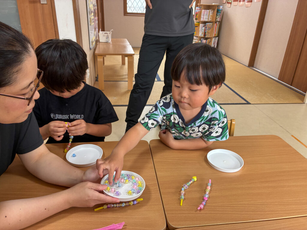 スタッフと一緒に皿のビーズを選ぶ様子