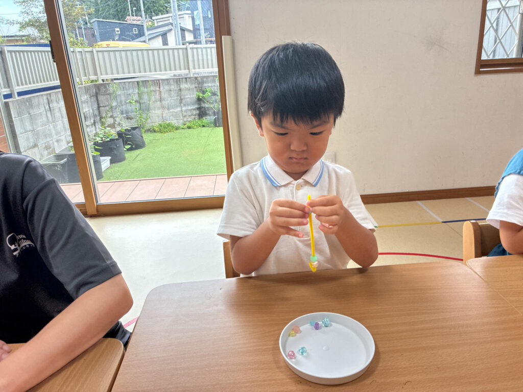 モールに通したビーズを両手で持つ様子