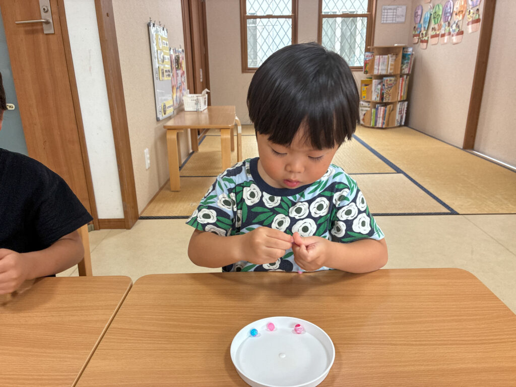 両手を寄せてビーズを通す様子