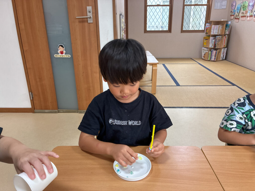 次に使うビーズを皿から選ぶ様子