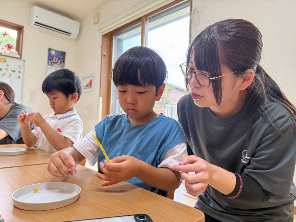 スタッフと並んでモールの先を見ながら作る様子