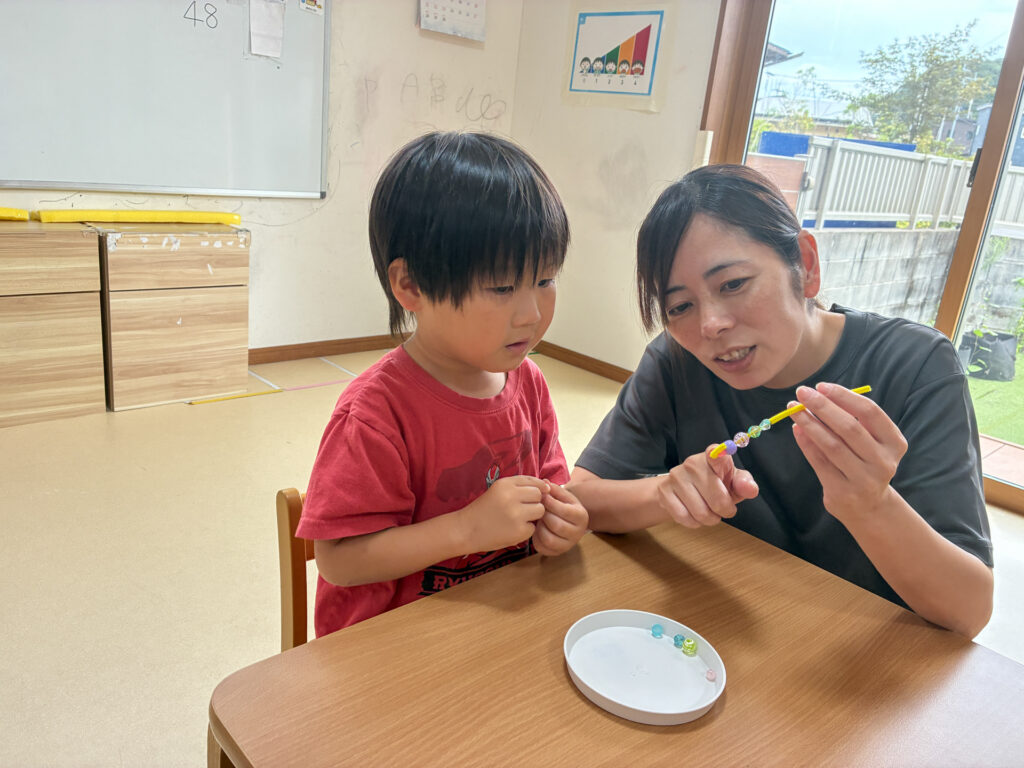 スタッフとビーズの付いたモールを見る様子