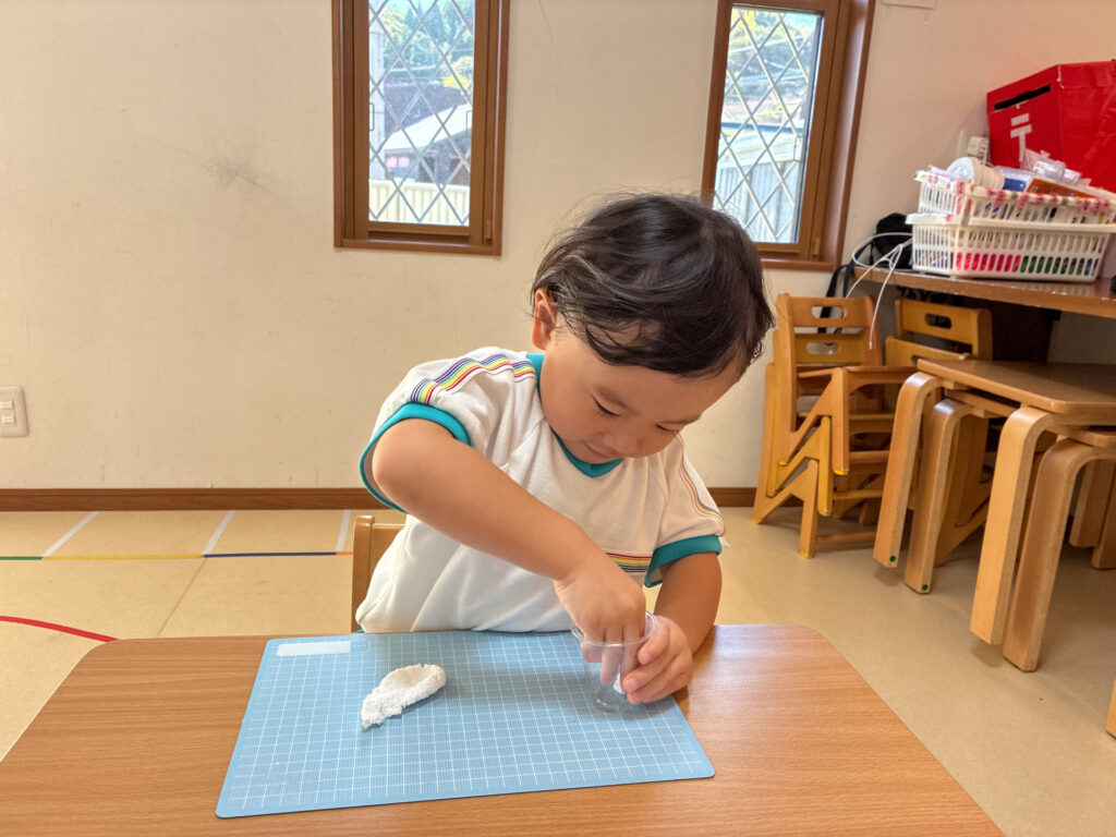 粘土を小さなカップに入れる様子