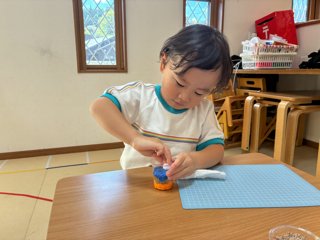 カップの中に色の違う粘土を重ねる様子