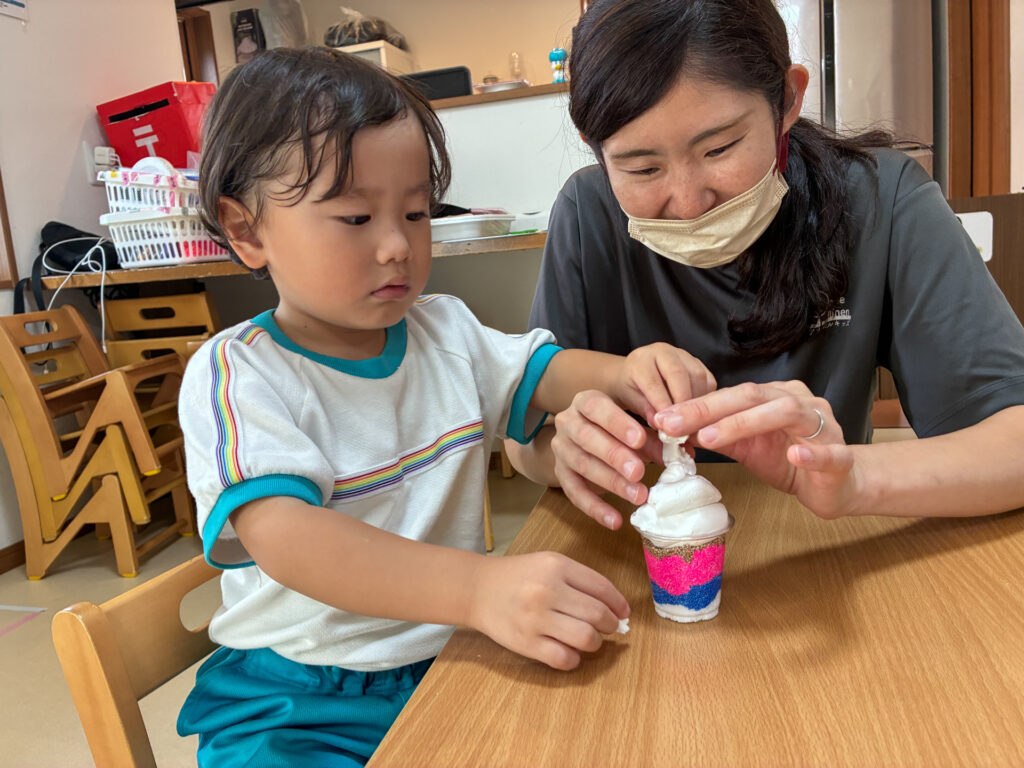 スタッフとパフェの上の飾りを整える様子