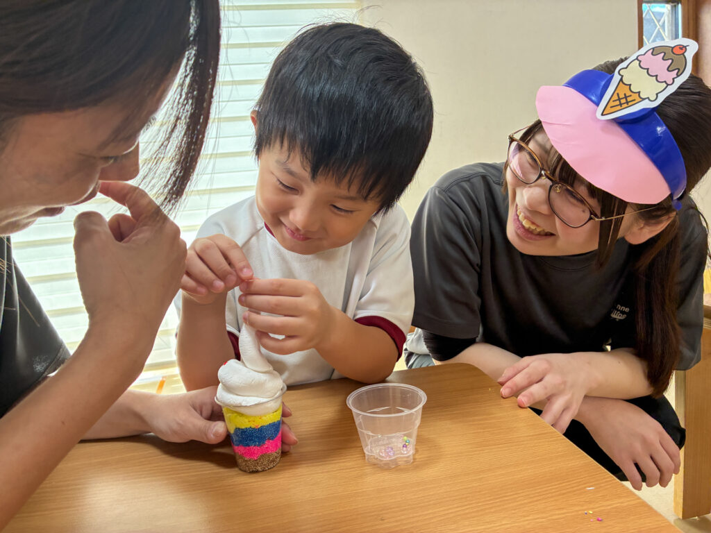スタッフと粘土のパフェに小さな飾りを付ける様子