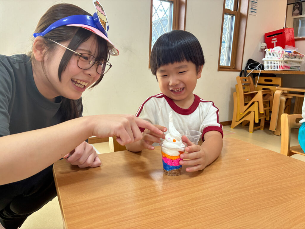 できあがったパフェを前にスタッフと笑う様子
