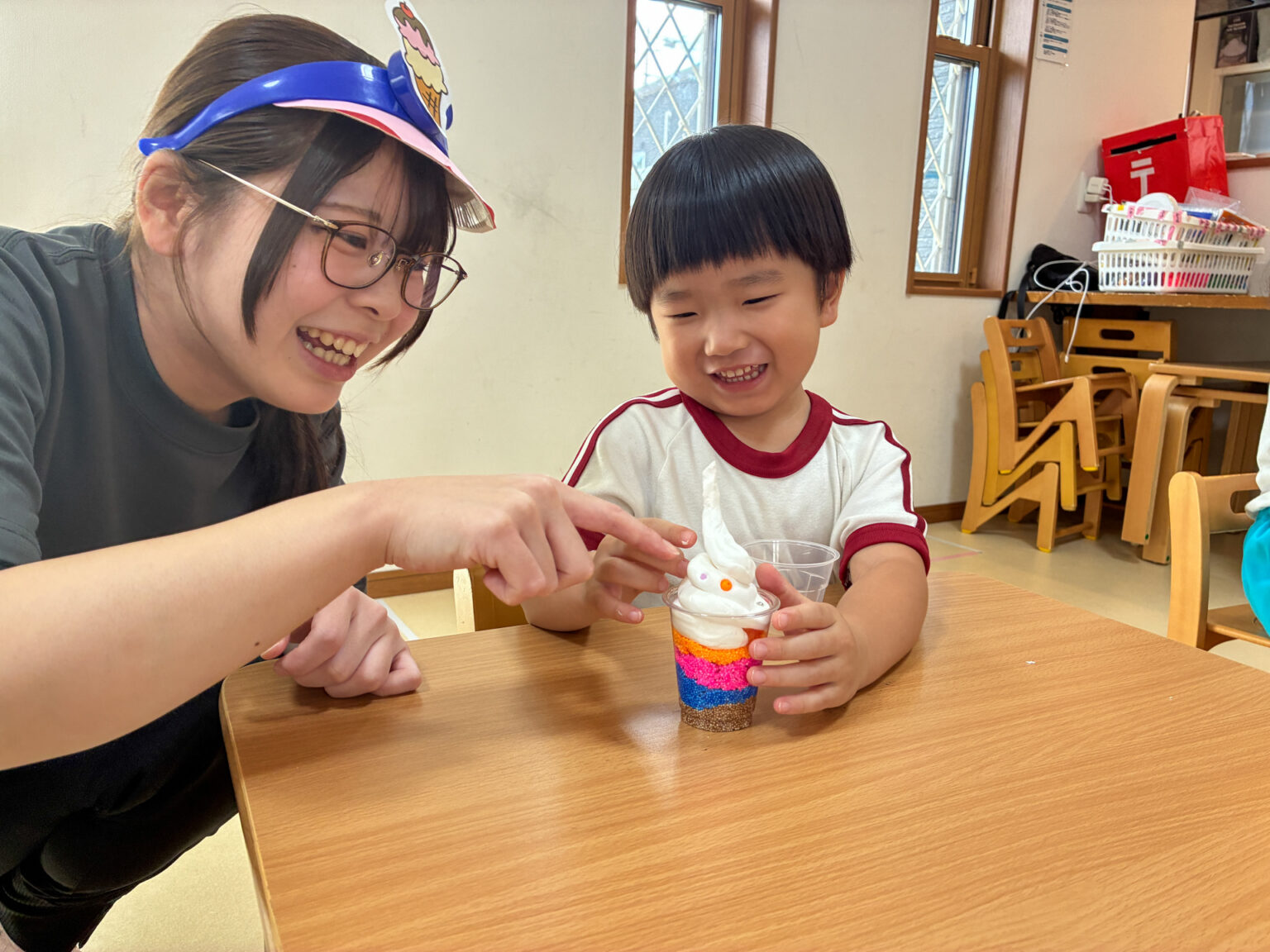できあがったパフェを前にスタッフと笑う様子