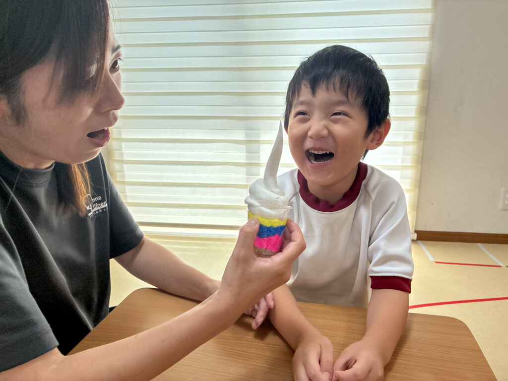 粘土のパフェを見て大きな笑顔を見せる様子