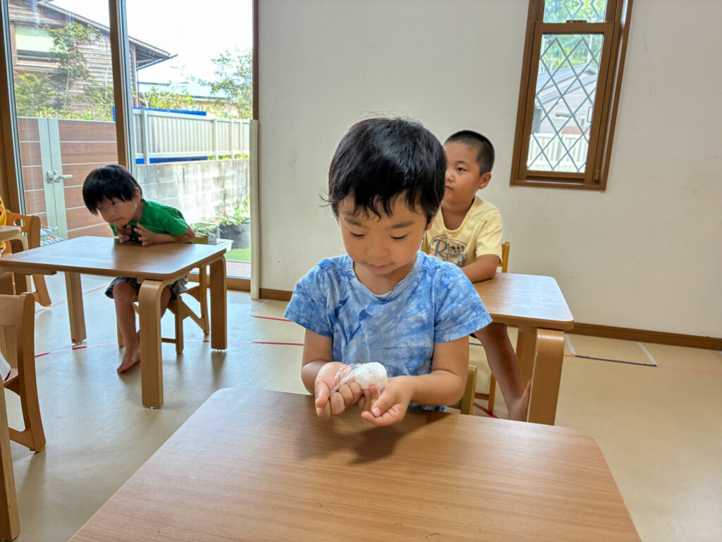 両手の上で白い粘土を丸める様子
