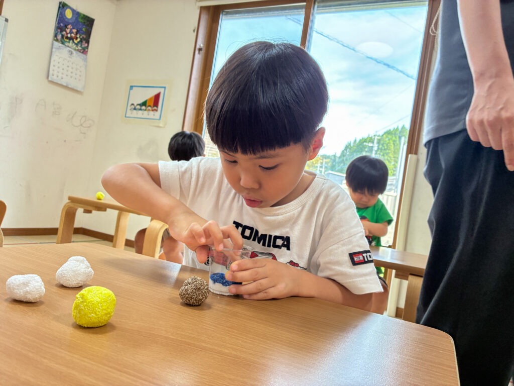 カップの中に色の違う粘土を重ねる様子