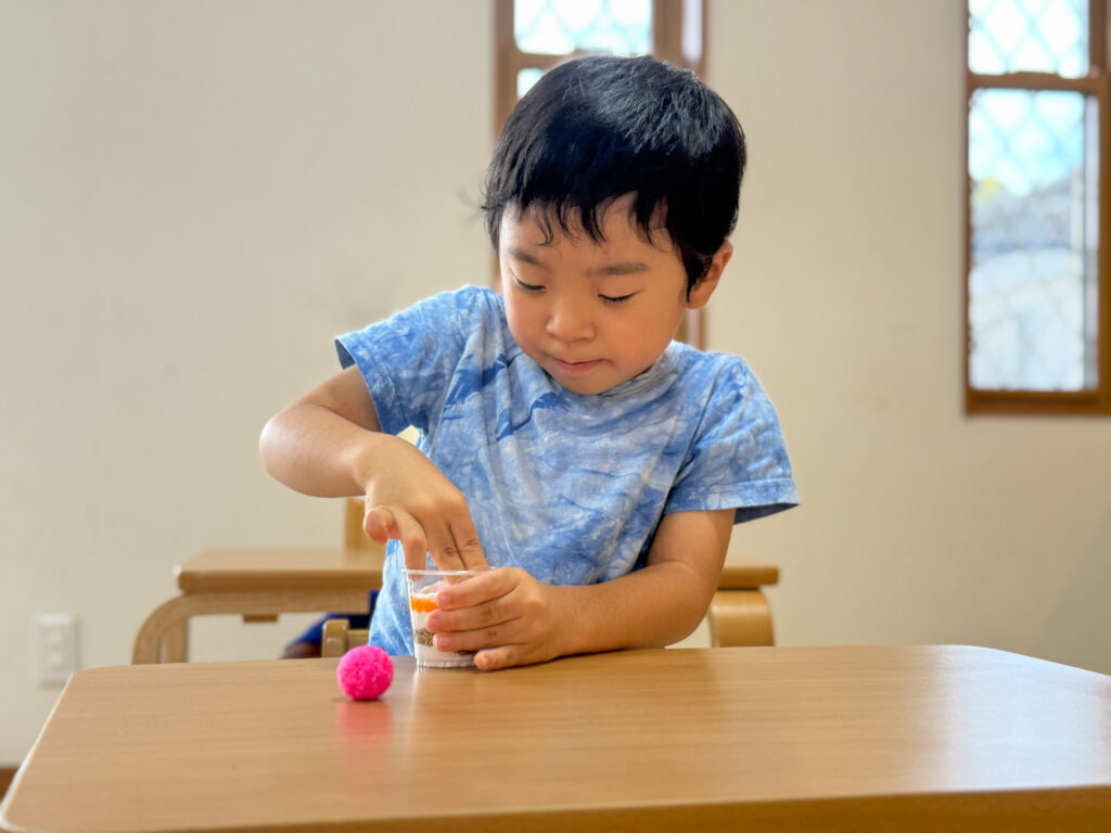 指で押してカップに粘土を詰める様子