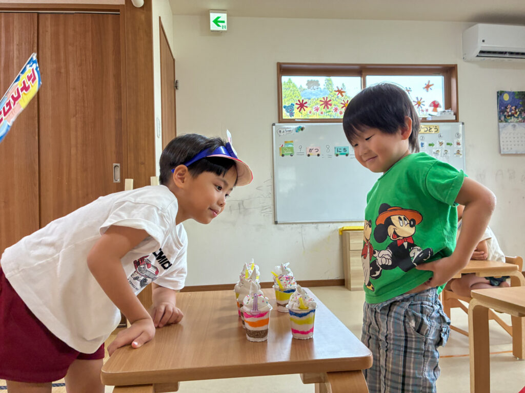 机に並んだパフェをはさんで友だちと向き合う様子