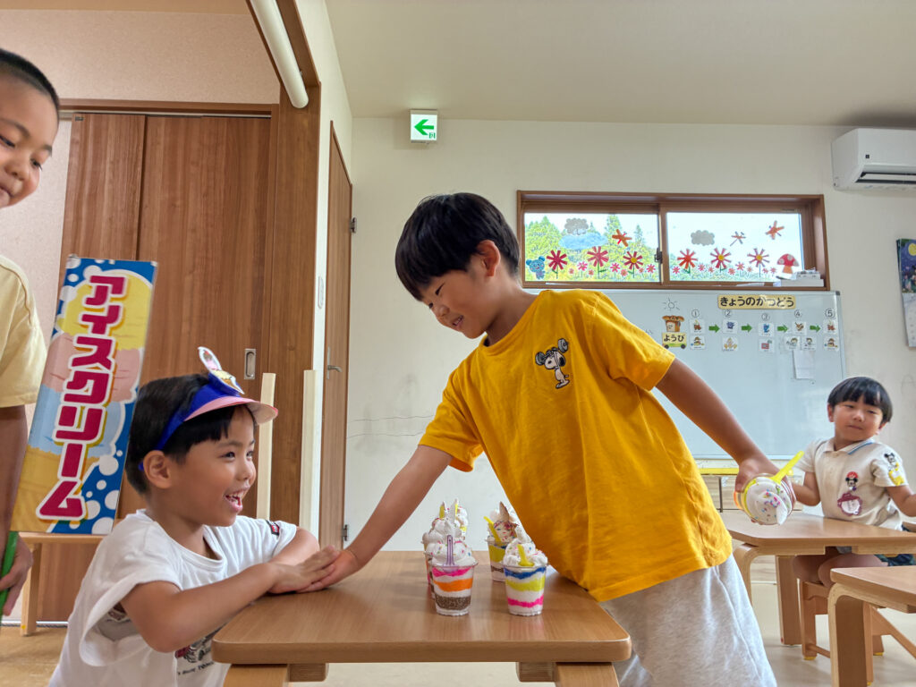 お店屋さん役の友だちと机ごしに話す様子