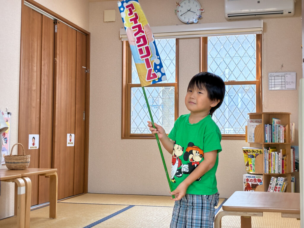アイスクリームの旗を持って立つ様子