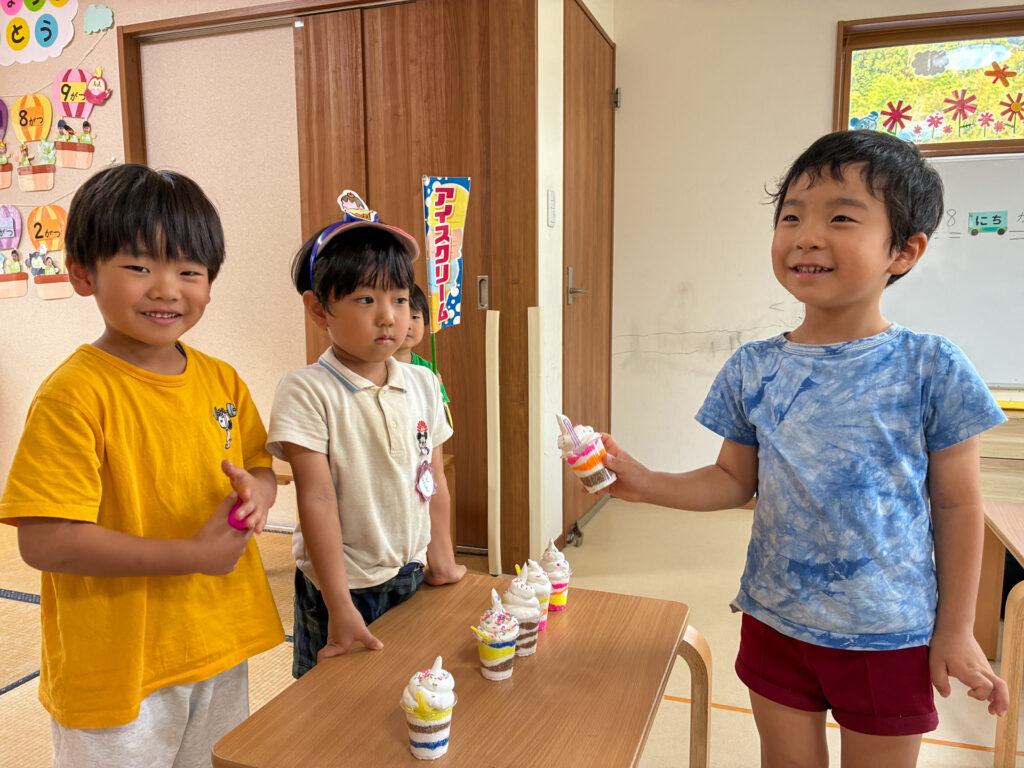 パフェを並べた机を囲んで笑顔を見せるこどもたち