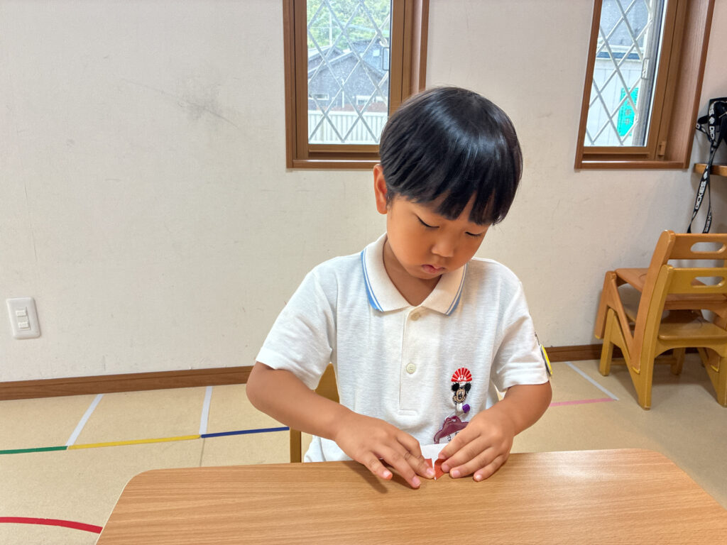 小さく折った紙の形を整える様子