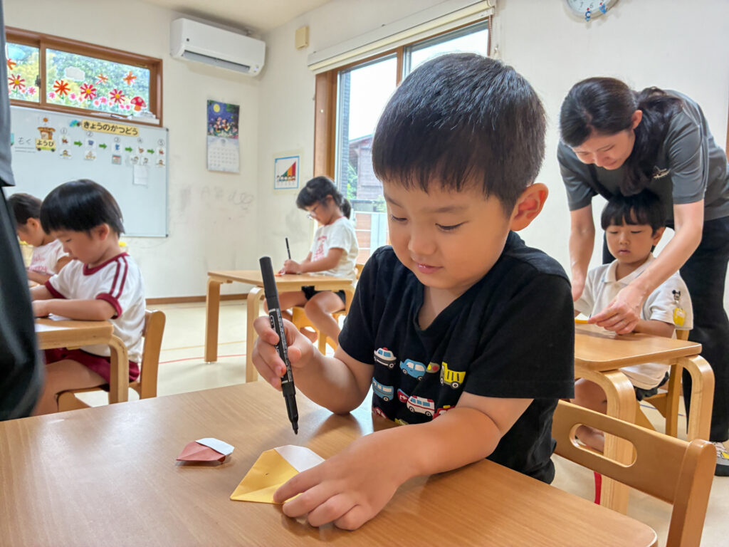 折り紙で作った栗にペンで描き込む様子