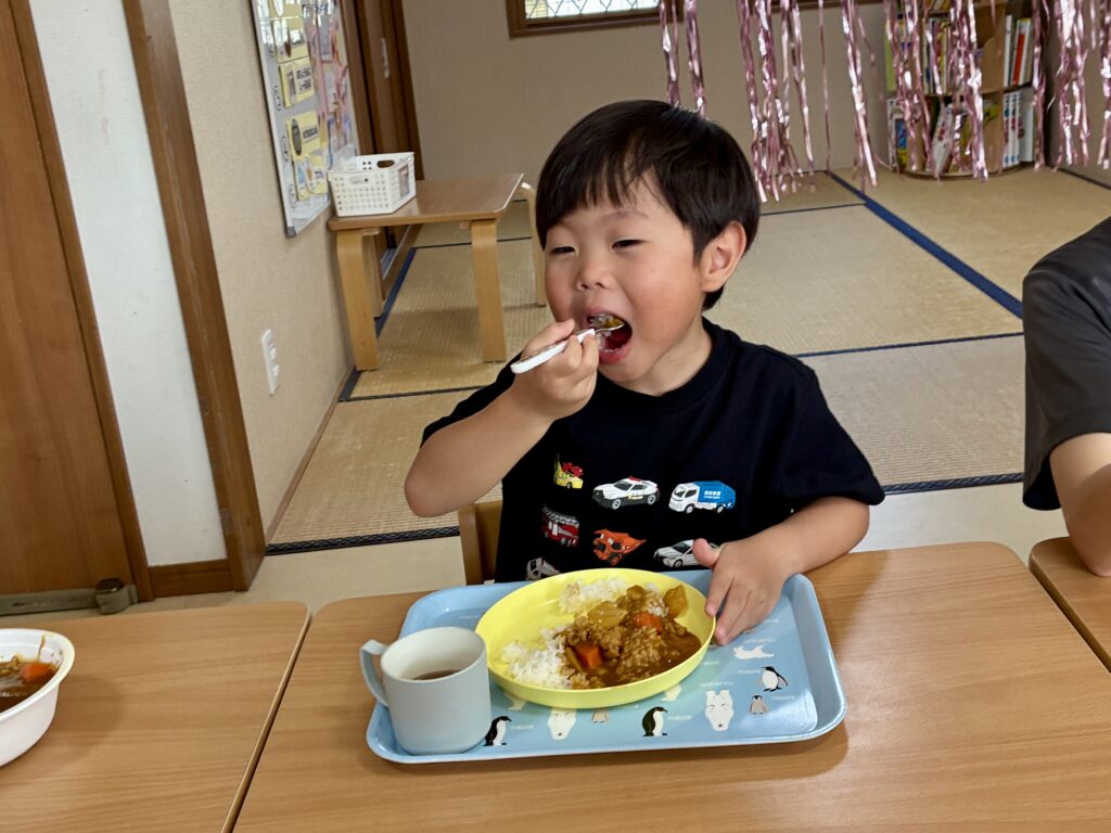 スプーンでカレーライスを食べるこども