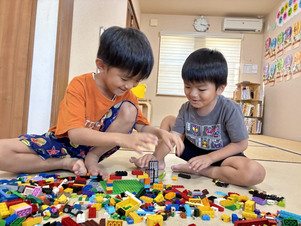 スタッフと一緒にブロックに取り組むお友達たち