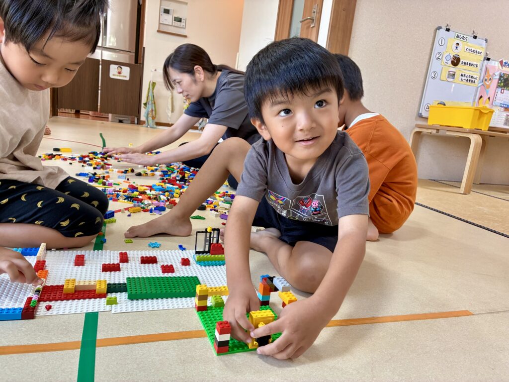 ブロックの板の上で集中して組み立てる手元