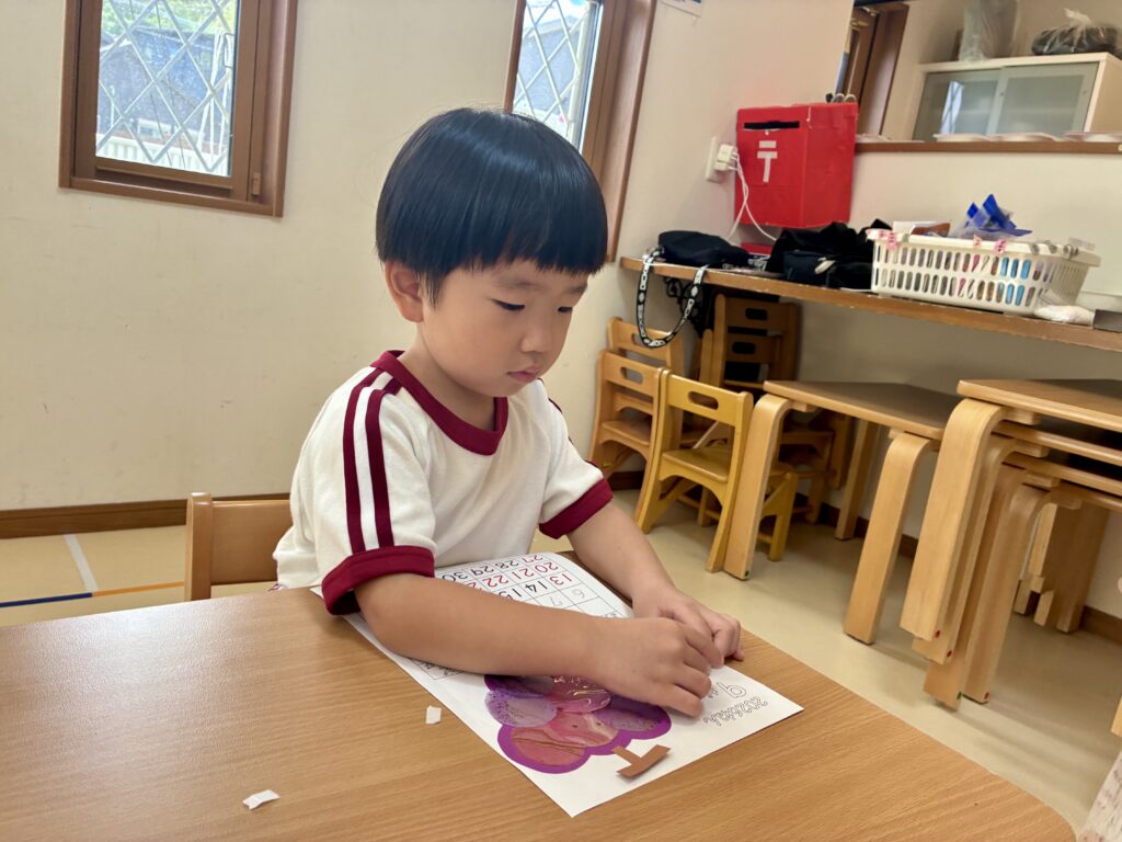 紙を見ながら鉛筆で名前や数字を書く手元