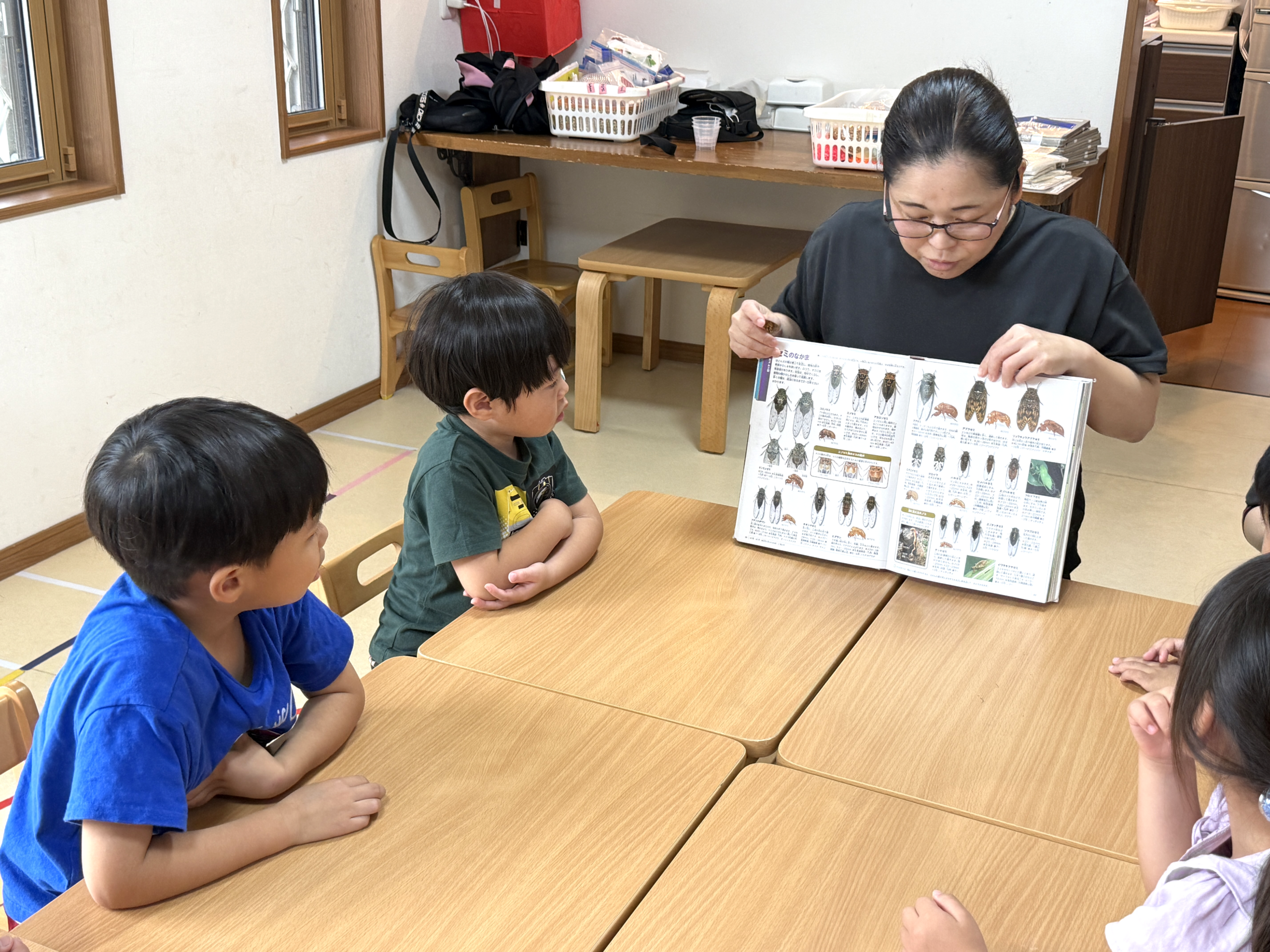 スタッフが図鑑をみんなに見せる