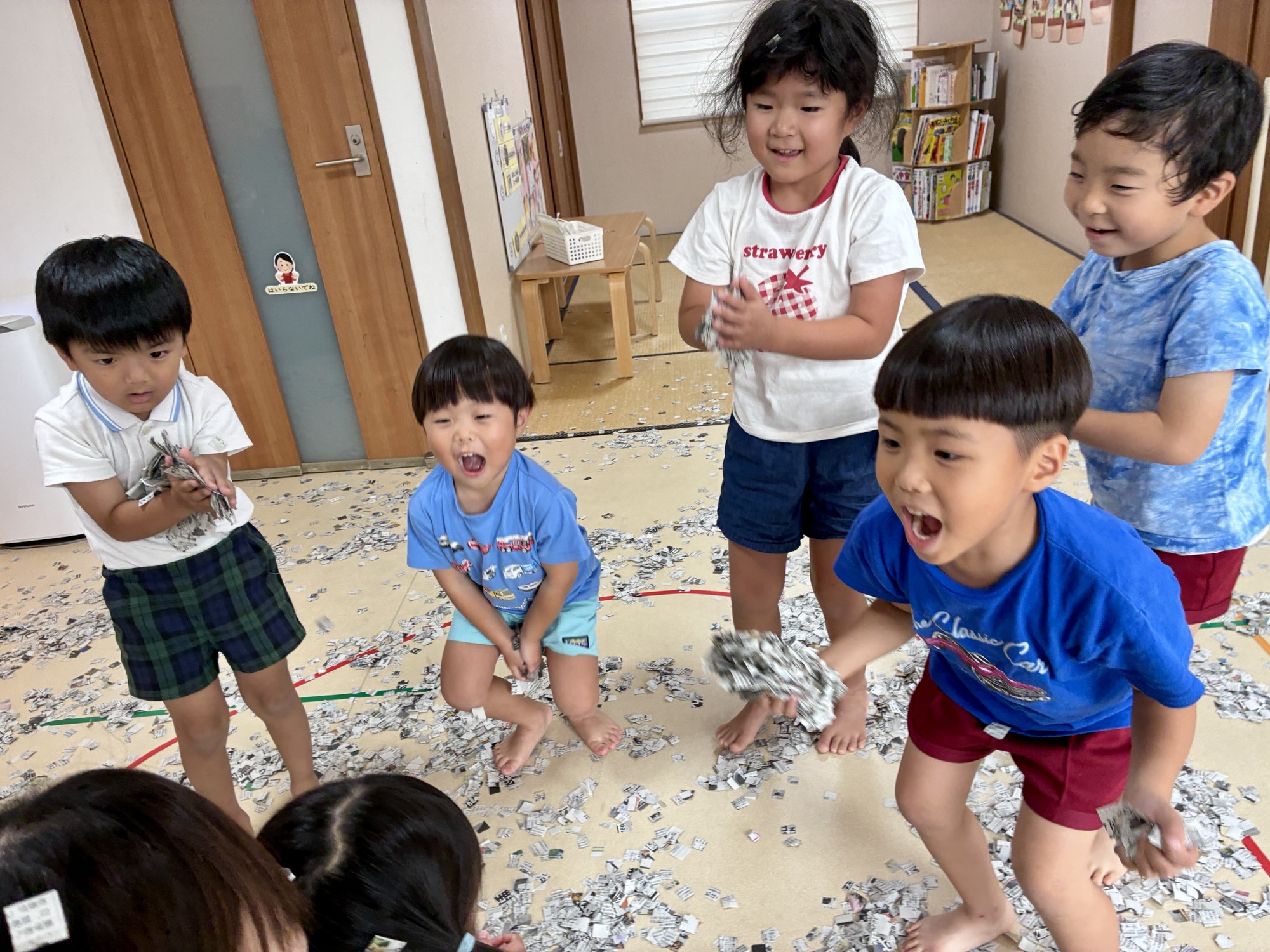 手いっぱいの紙吹雪を持ち、笑顔で輪になったお友達