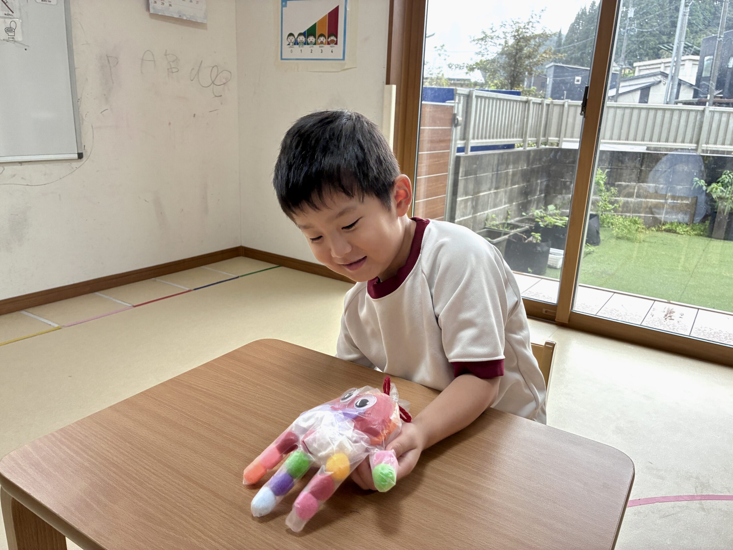 完成したおばけを手にはめて見つめる子ども